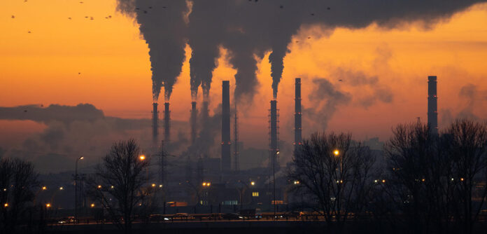 Smoke from heating station in winter season, view at sunset. Air pollution and emission fuel problem